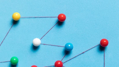 Gekleurde prikspelden met lijnen daartussen als symbool voor verbinding van teams in de Obeya