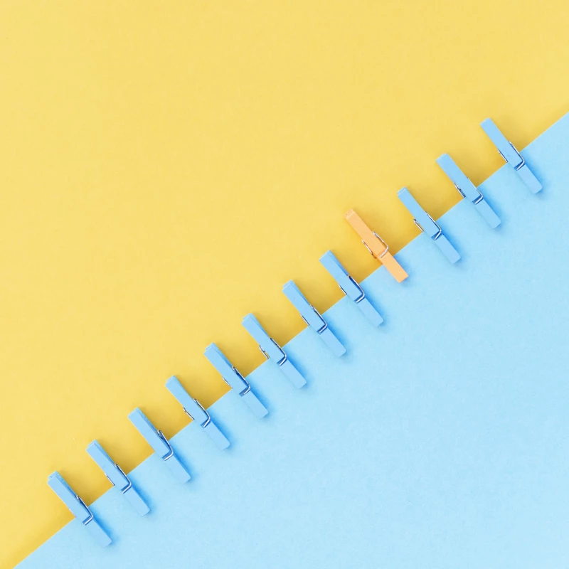 Abstracte weergave van Visual Management een gele en blauwe driehoek met afwisselende kleur wasknijpers.