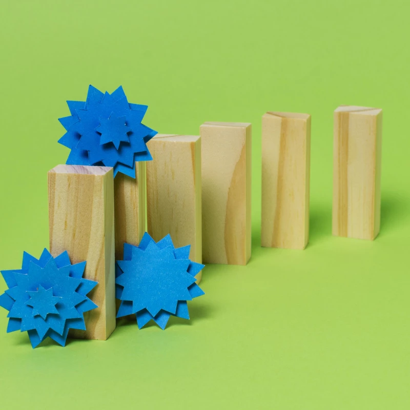 Abstract beeld van houten blokjes, waarvan bij een houten blokje er blauwe propjes omheen liggen, wat de bottleneck voorstelt