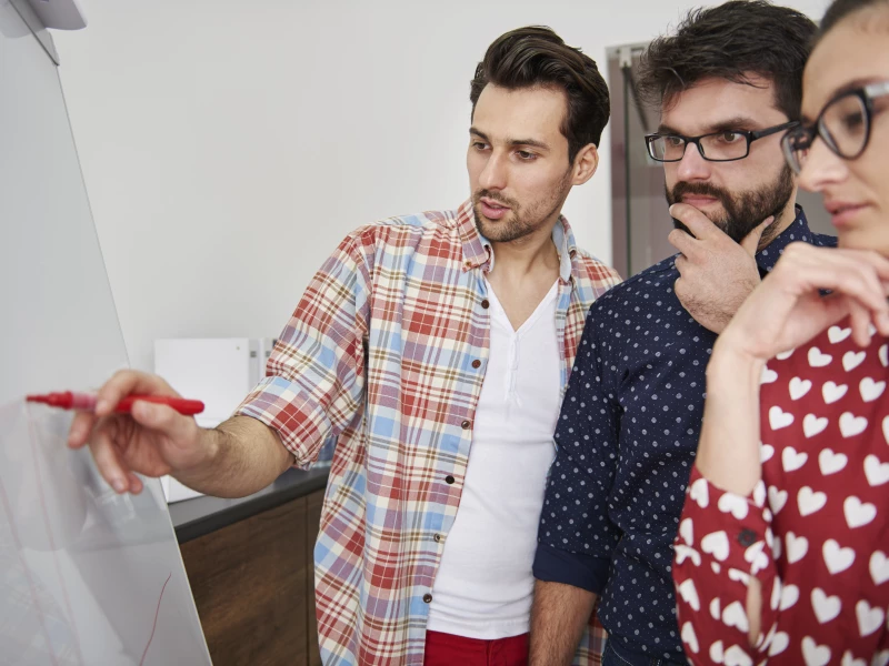 Medewerkers staan rondom een flipover en denken na hoe ze flow in hun processen kunnen krijgen