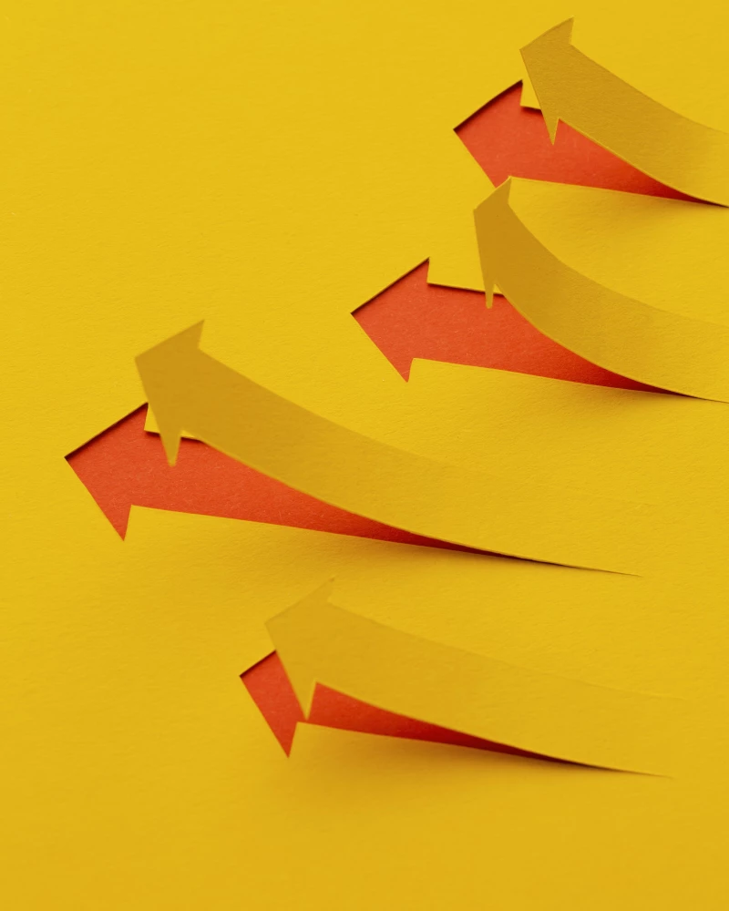 Een papieren vel waaruit pijlen zijn geknipt die omhoog staan, tekenend voor het verbeteren van de dagelijkse werkprocessen met Lean